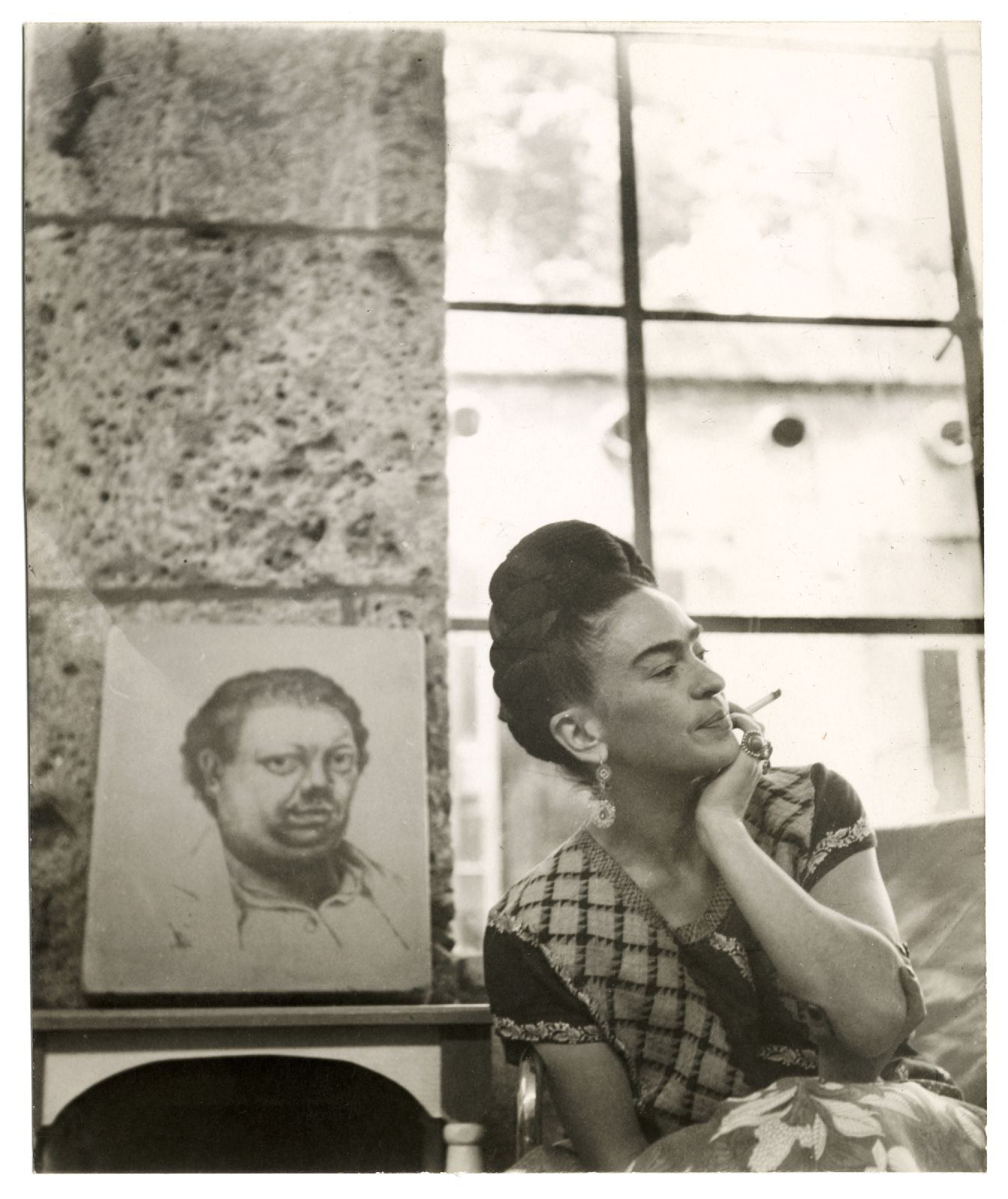 Frida Kahlo con un autoritratto di Diego Rivera, Coyaca, 1945 circa. Foto di Lola Alvarez Bravo. Riproduzione di Libby Rosof.