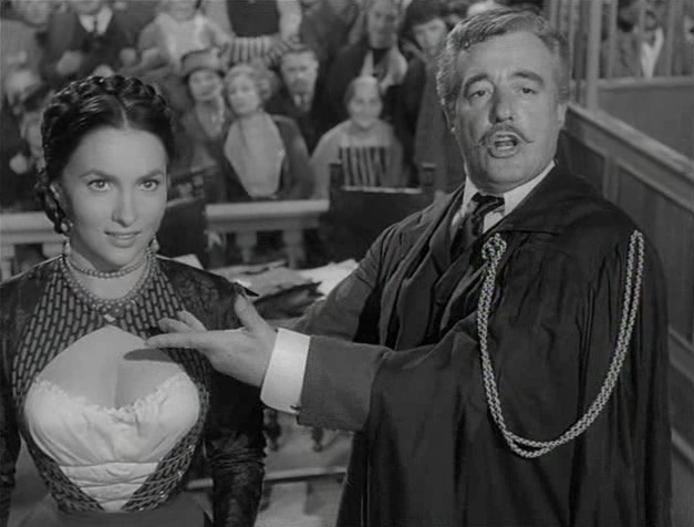 Gina Lollobrigida e Vittorio De Sica nell'episodio <em>Il processo di Frine</em> di <em>Altri tempi</em>.
<br>Immagine in pubblico dominio. Fonte: <a href=https://it.wikipedia.org/wiki/File:Altri_tempi-Il_processo_di_Frine3.jpg>Wikipedia</a>.